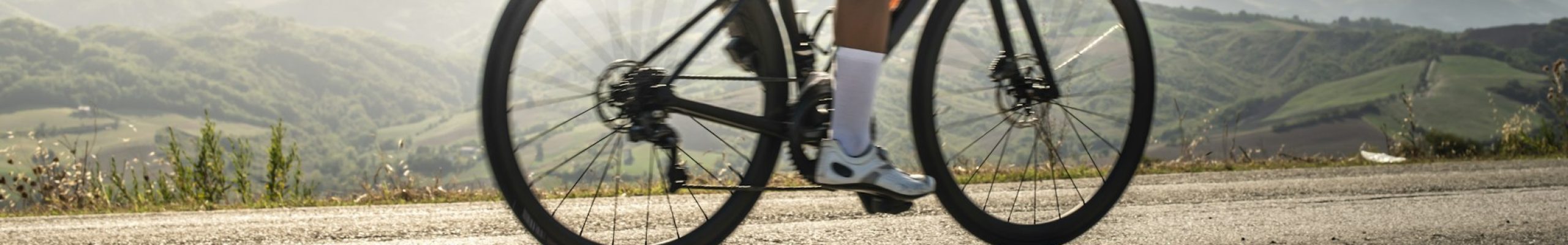 Cyclist sports on road. Sun Rays and shadows from the bike on th